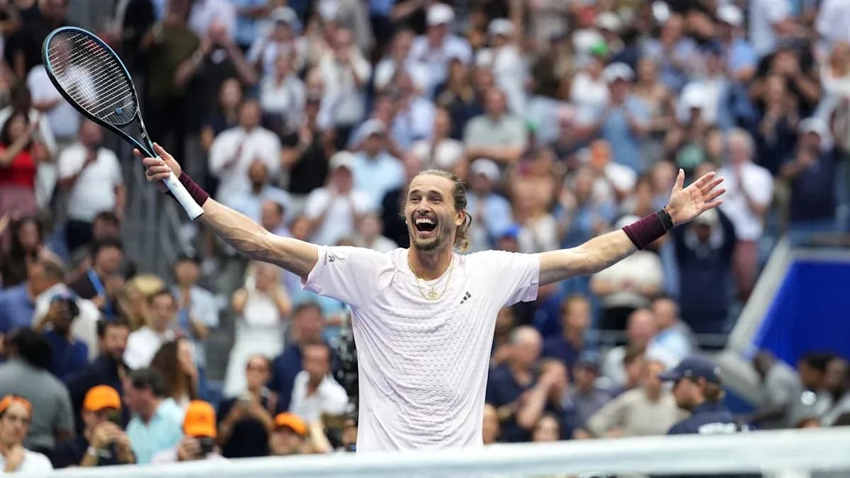 Tennis player celebrating with arms raised in crowd