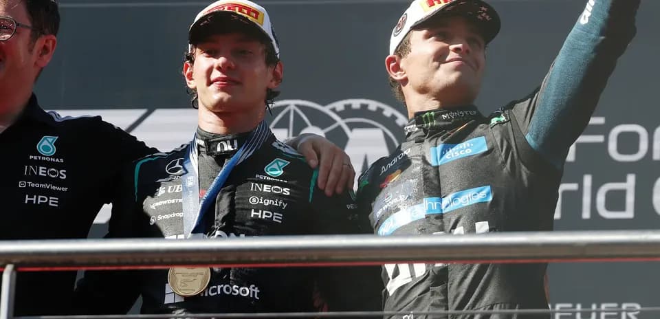 Two drivers celebrating on podium after race