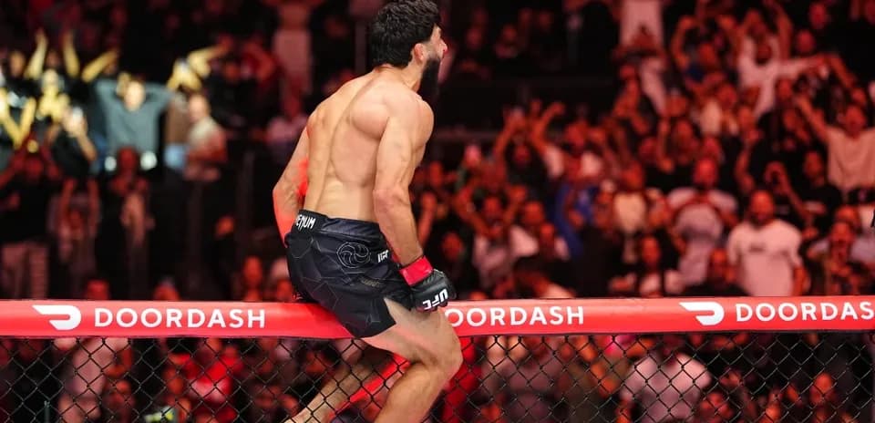 Fighter celebrating on the cage after victory