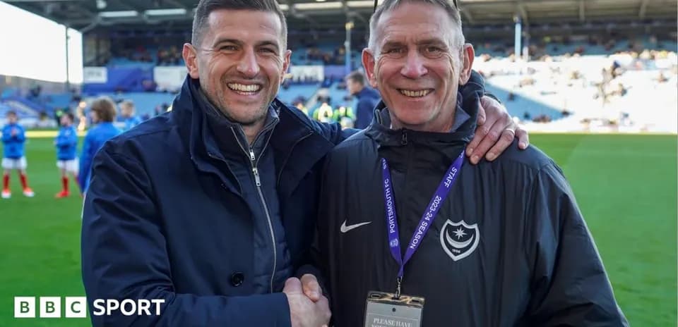 Two men shaking hands on a football pitch
