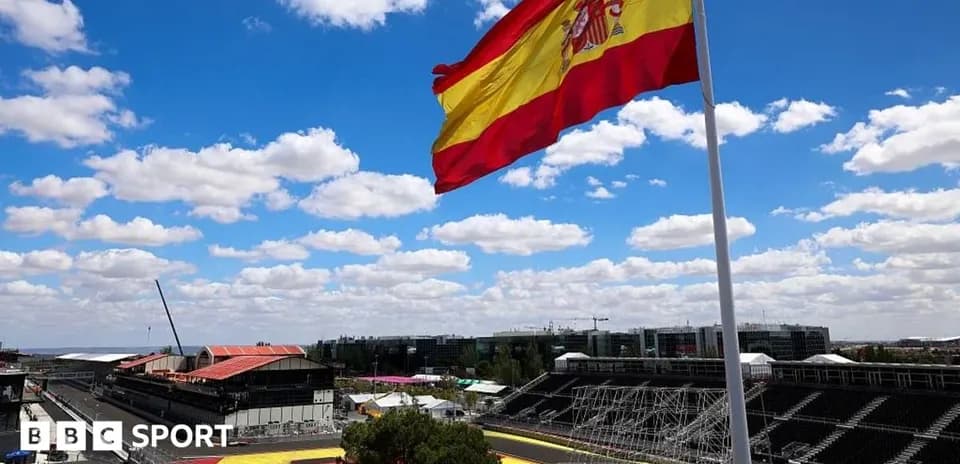 Spanish flag waving at racetrack under blue sky