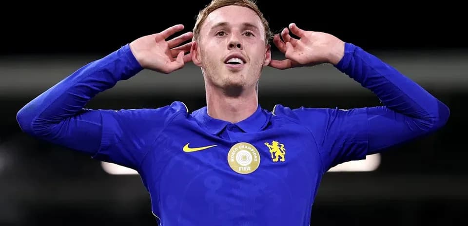 Player celebrating with hands behind ears in blue kit
