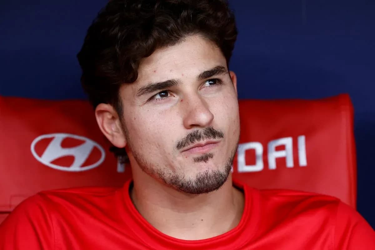 Player sitting on the bench in red jersey