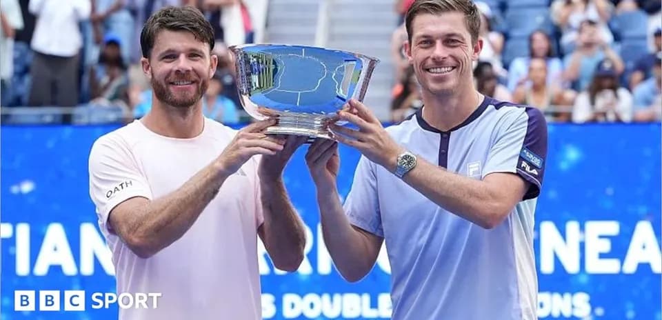 Two tennis players holding trophy after winning tournament