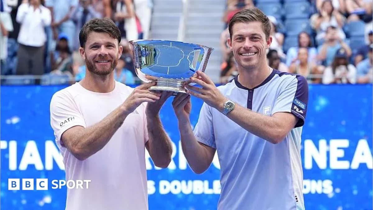 Two tennis players holding trophy after winning tournament