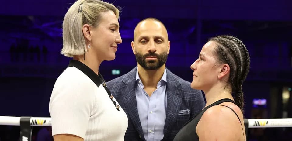 Two fighters facing off with a referee in between