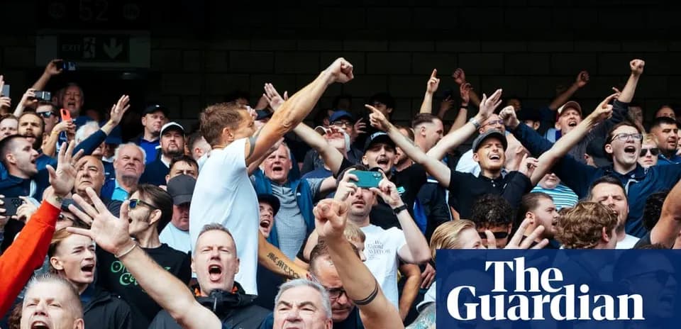 Crowd of fans cheering passionately at a sporting event