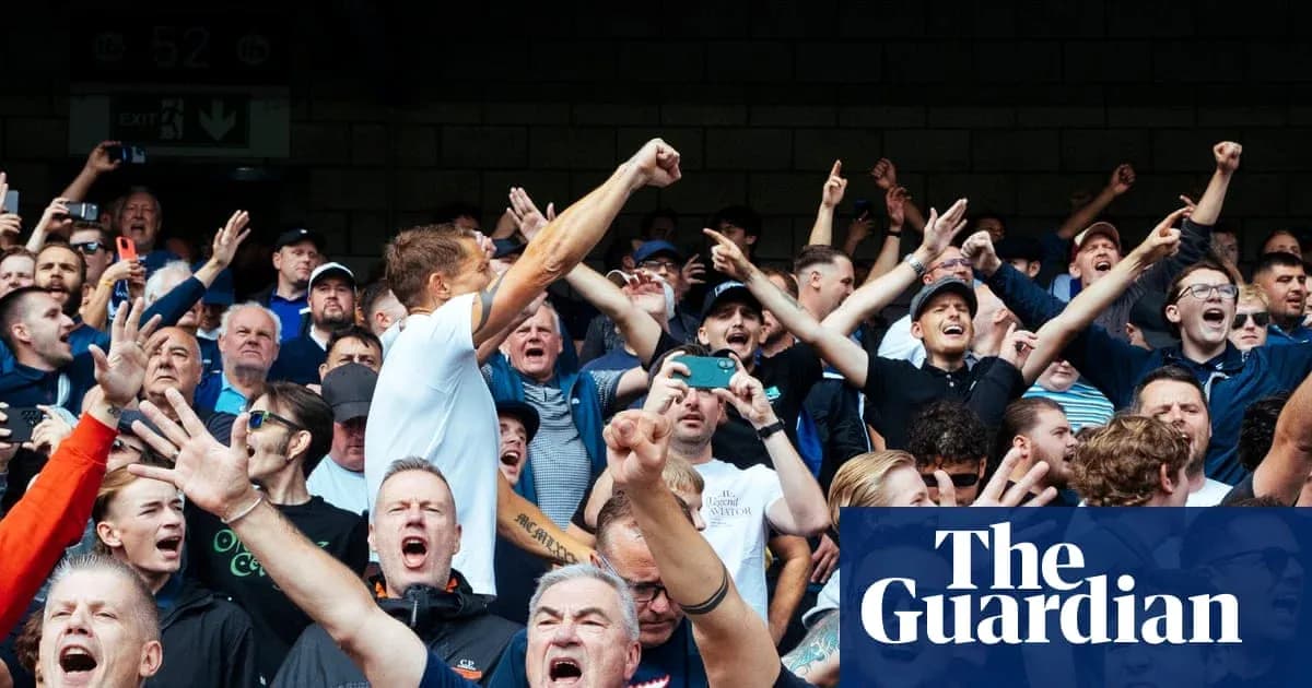 Crowd of fans cheering passionately at a sporting event