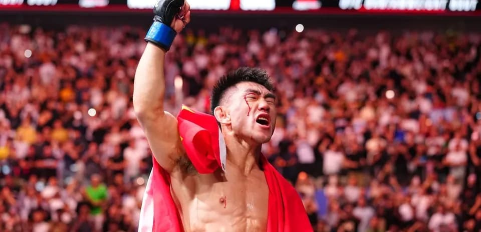 Fighter celebrating victory with a flag in crowd