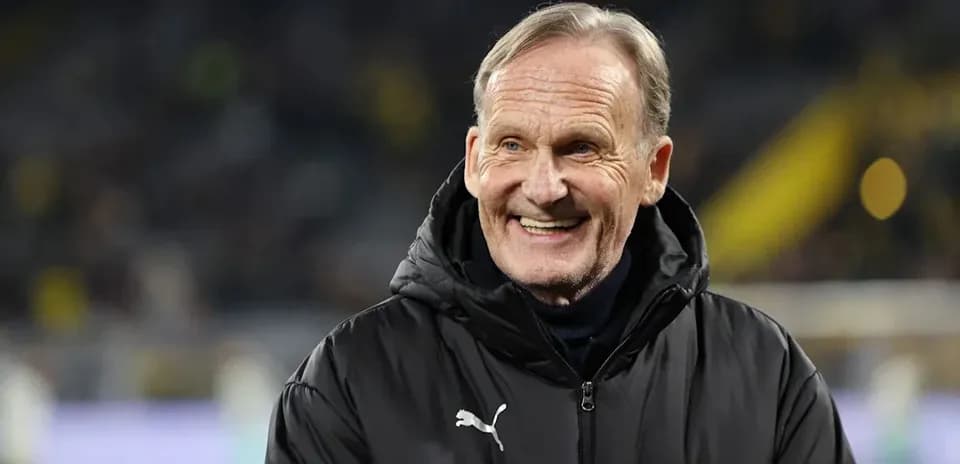 Man smiling on the sidelines during a match