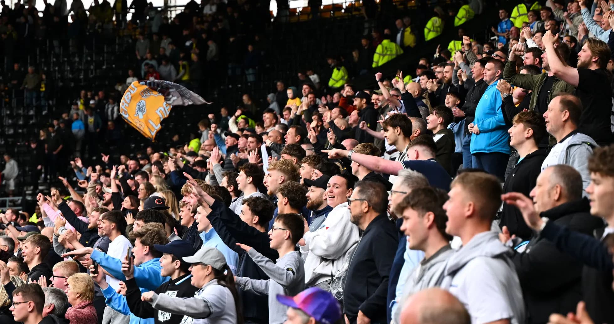 Crowd of fans cheering enthusiastically in stadium