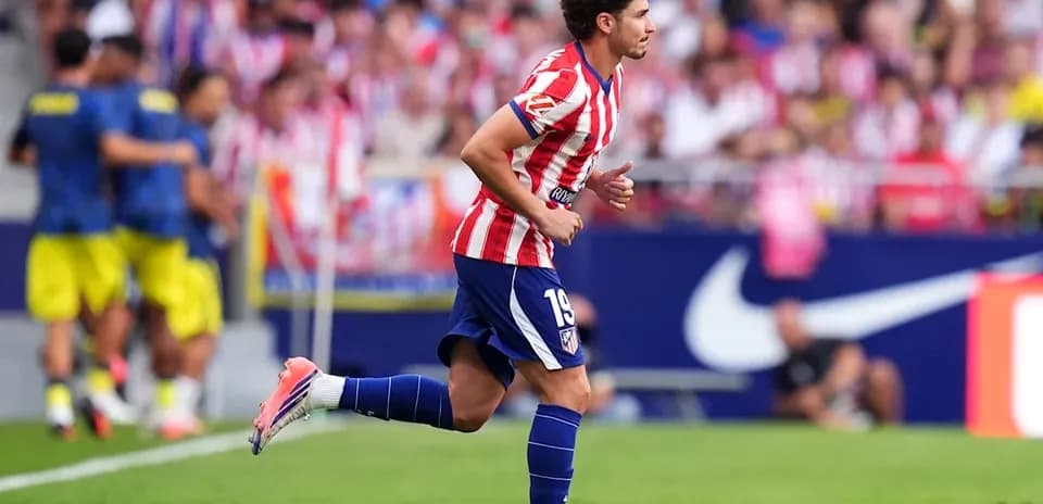 Player in Atlético Madrid kit running on field