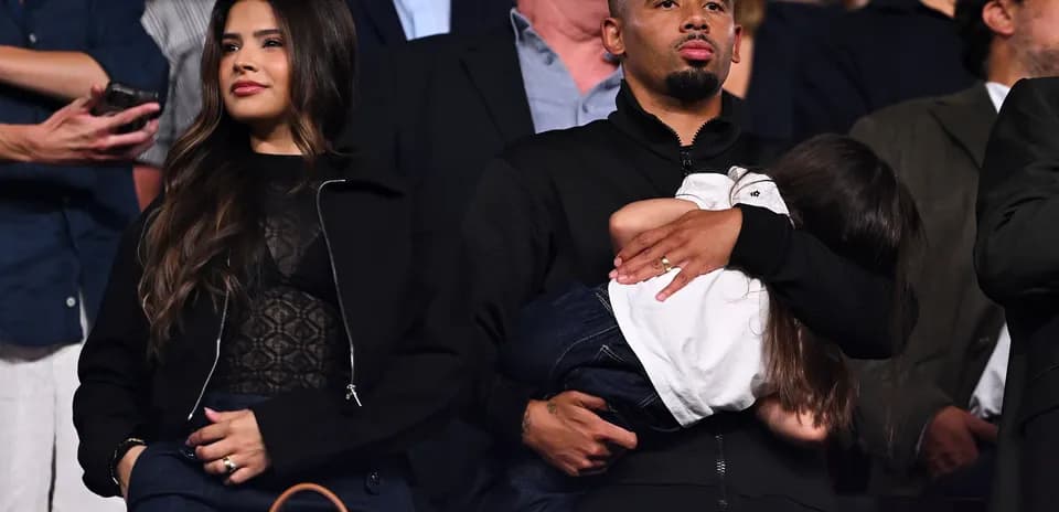 Man holding child, woman standing beside him