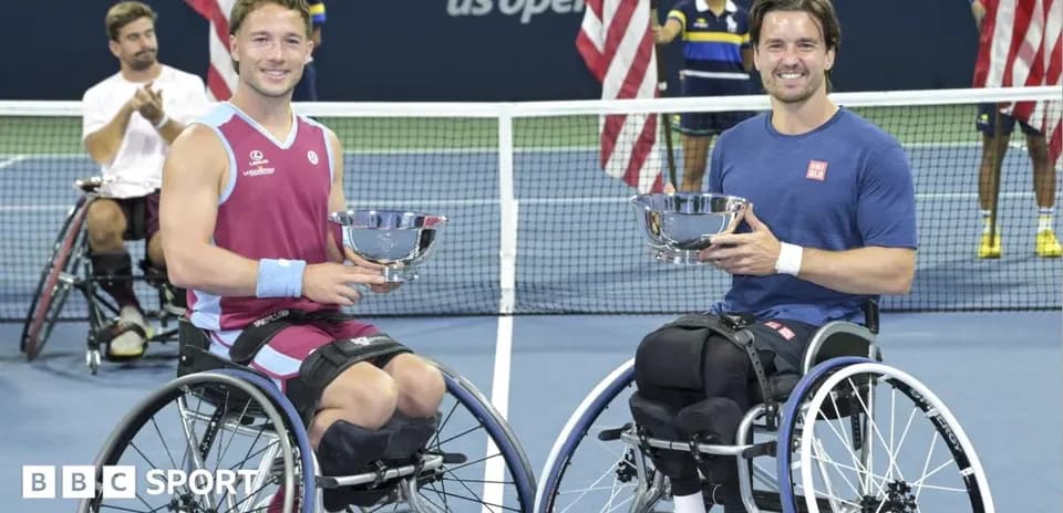 Two wheelchair tennis players holding trophies after match