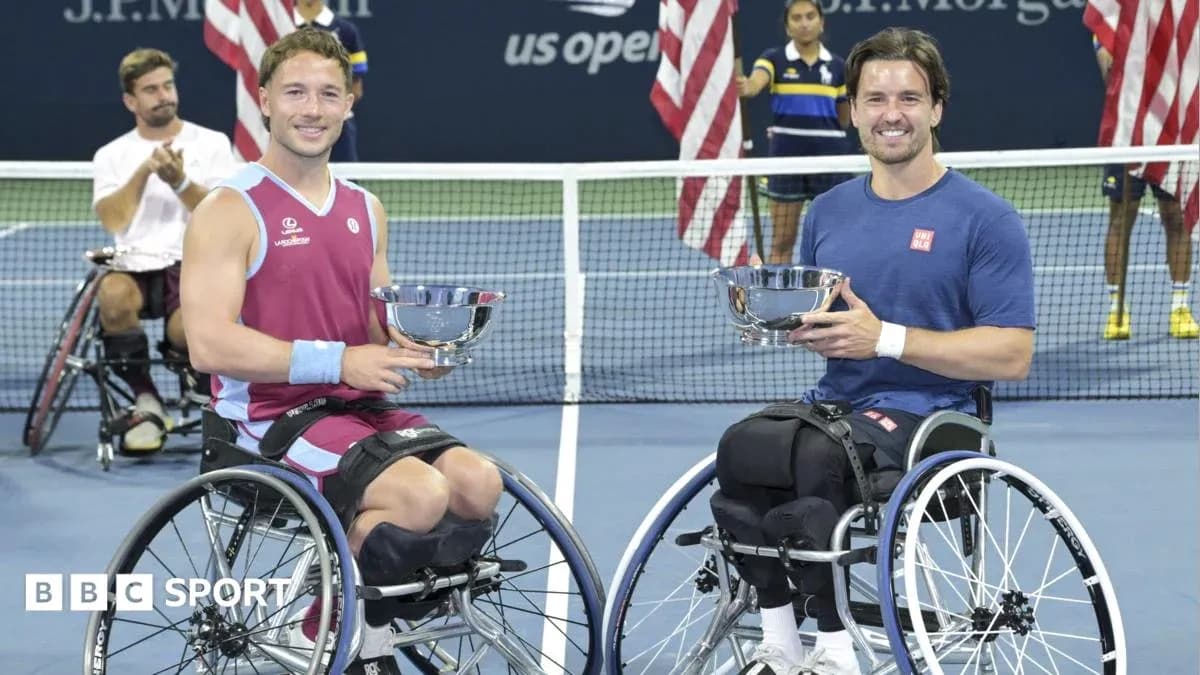 Two wheelchair tennis players holding trophies after match