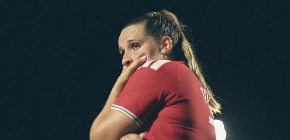 Player in red jersey with hand on face