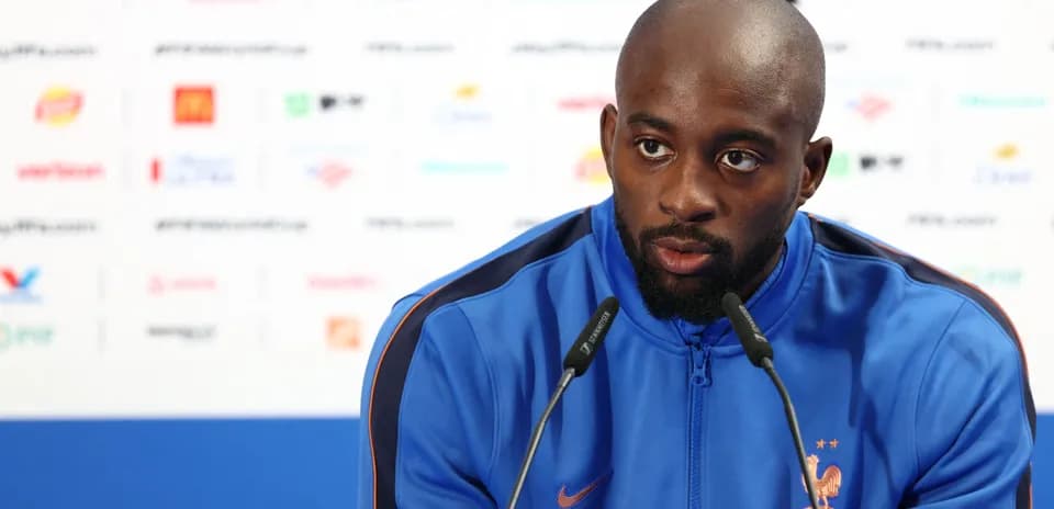 Player speaking at a press conference with microphones