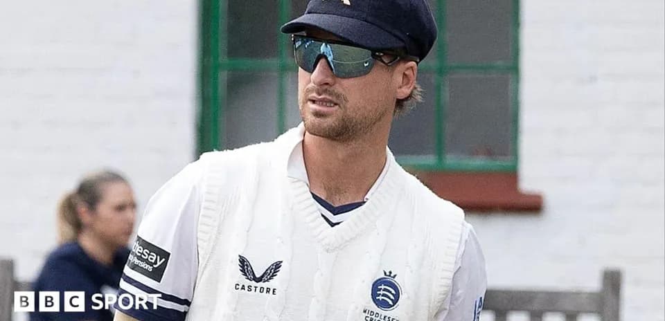 Cricketer wearing sunglasses and sweater on field