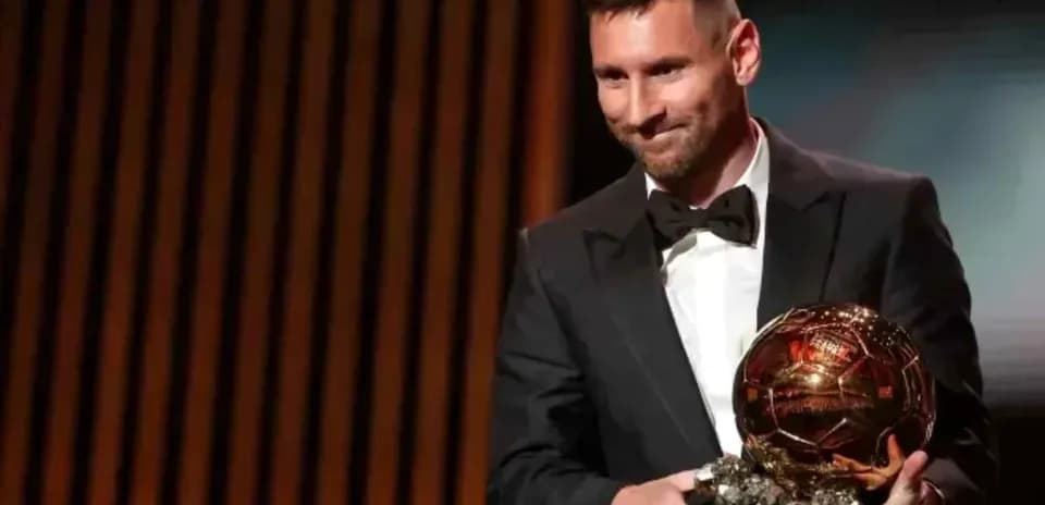 Player holding Ballon d'Or award on stage
