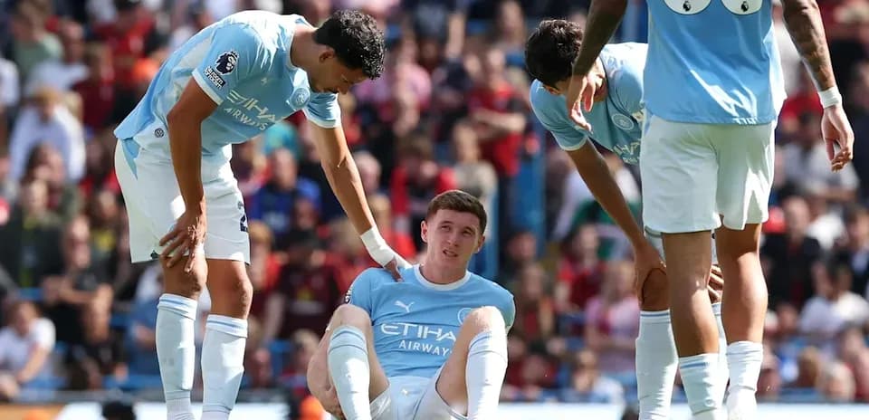 Player sitting on the ground with teammates assisting