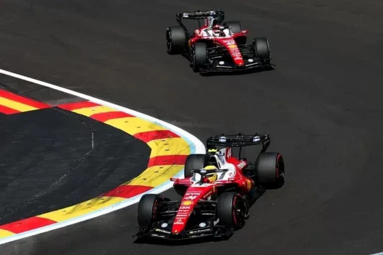 Two Ferrari cars racing around a corner