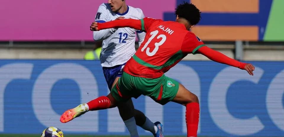 Player in red tackles opponent in blue during match