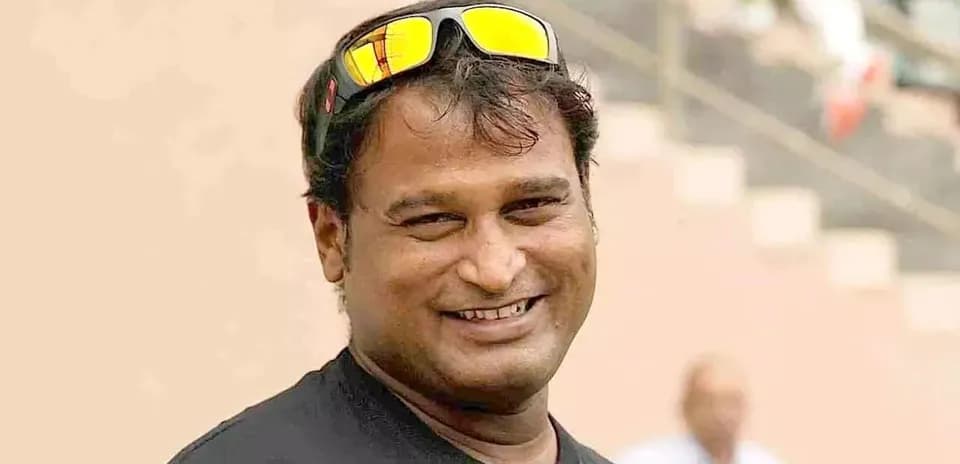Man smiling wearing sunglasses at stadium