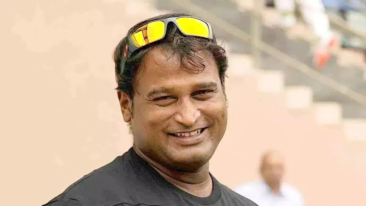 Man smiling wearing sunglasses at stadium