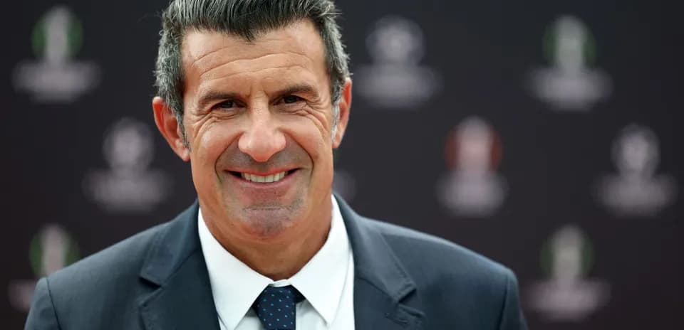 Man in suit smiling at press event backdrop
