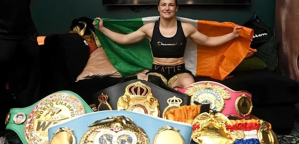 Boxer holding Irish flag with championship belts displayed