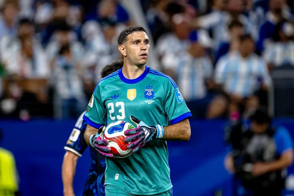 Goalkeeper in teal jersey holding soccer ball