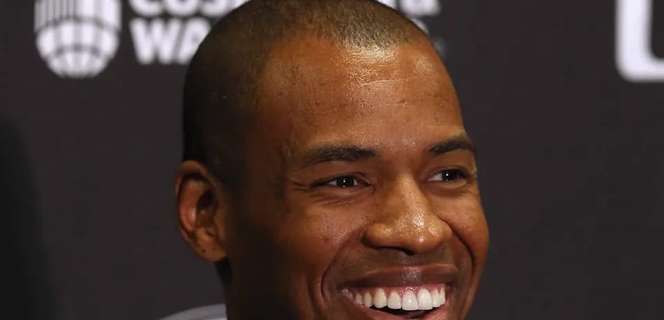 Smiling man at press conference backdrop