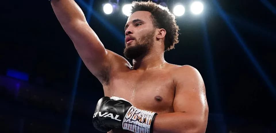 Boxer raising arm in victory after match