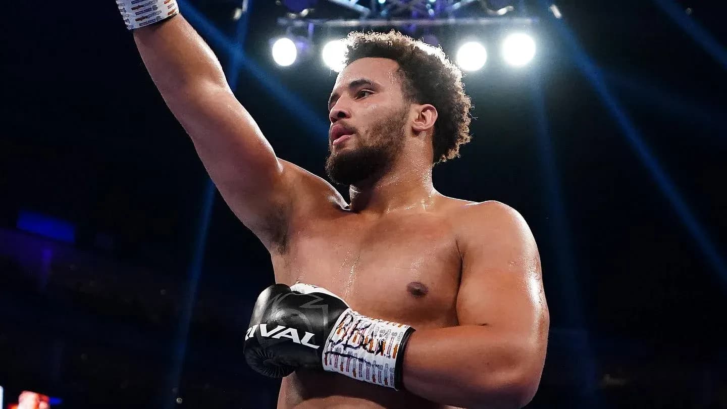 Boxer raising arm in victory after match