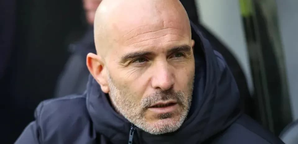 Coach in a dark jacket during a match