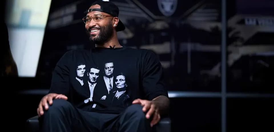 Athlete seated in interview setting, wearing graphic t-shirt