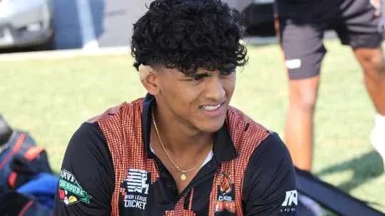 Young athlete sitting on field with team gear