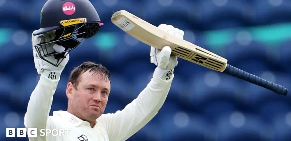 Cricketer celebrating with bat and helmet raised