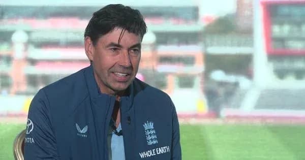 Man in England cricket team jacket speaking at event