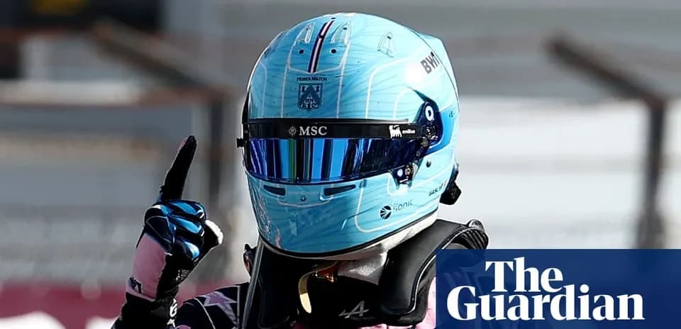 Racing driver celebrating with helmet and gloves raised