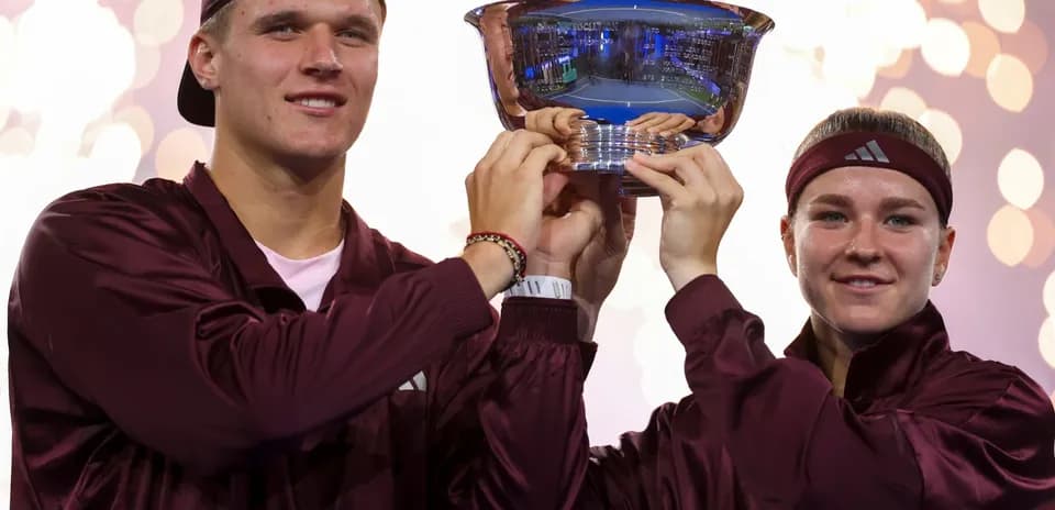 Athletes celebrating victory with trophy in hand