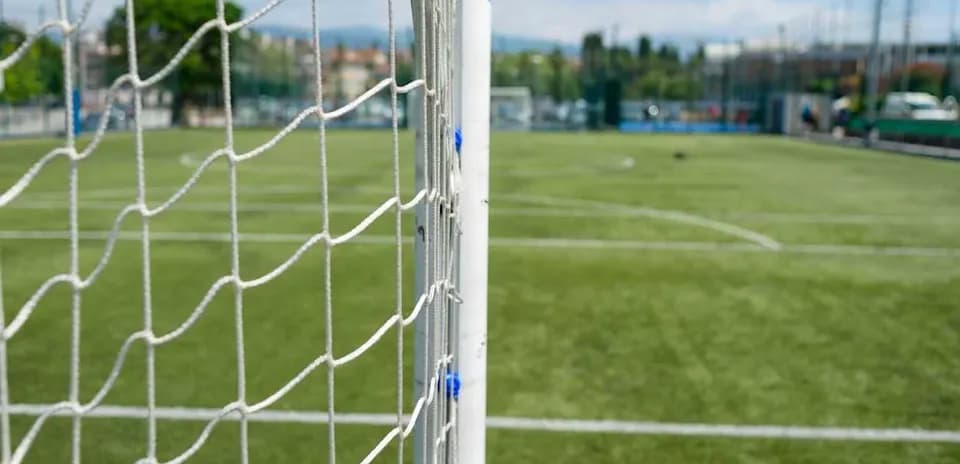 Close-up of soccer goal with field in background