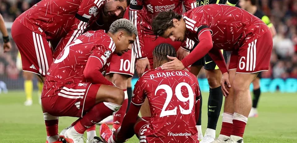 Liverpool players comforting injured teammate on pitch