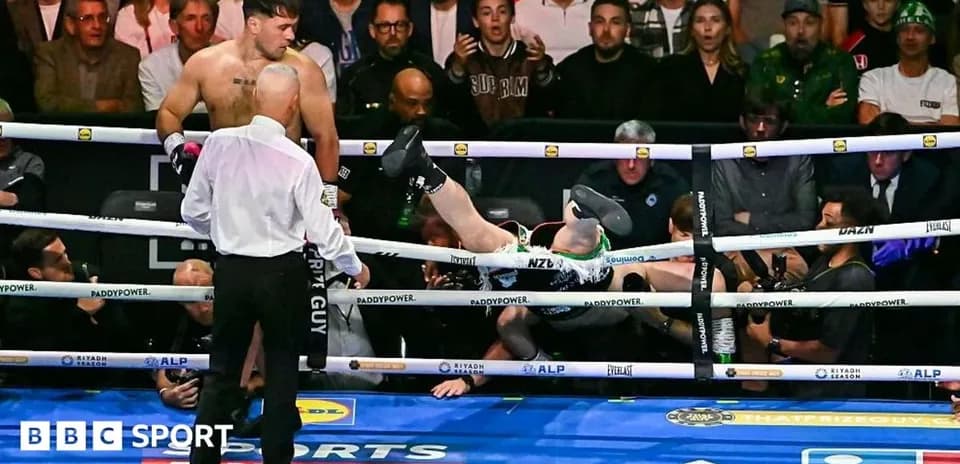 Boxer knocked out, falling outside the ring