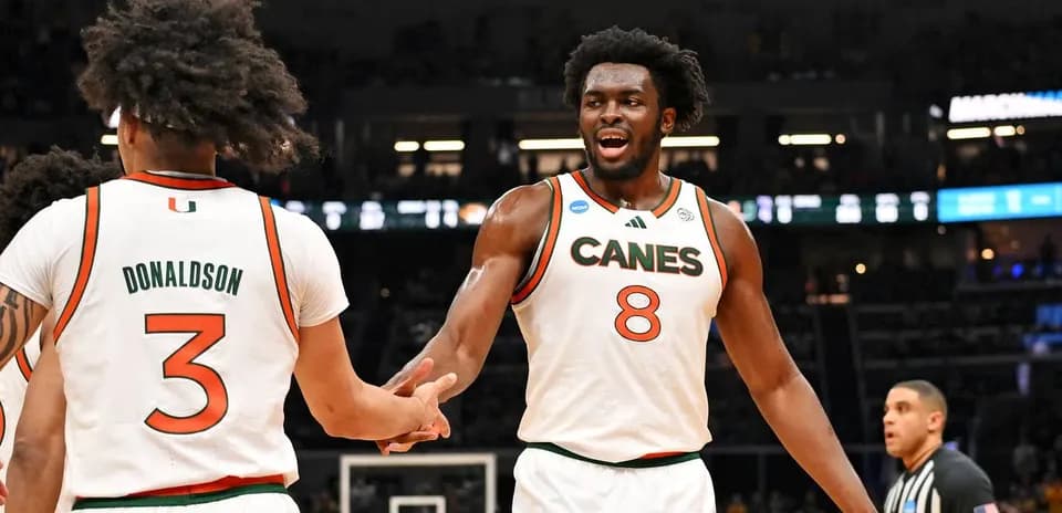 Two Miami players celebrating during a basketball game