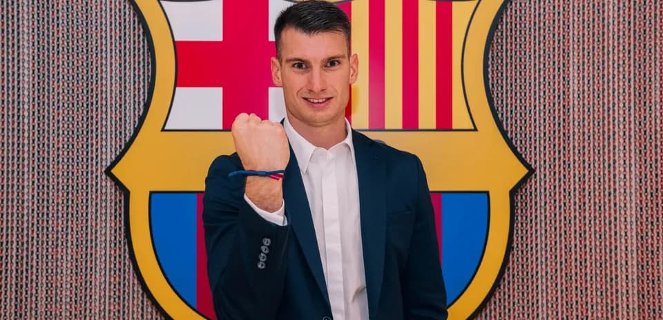 Player posing with Barcelona club logo backdrop
