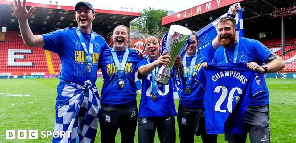 Celebrating team members holding trophy on field