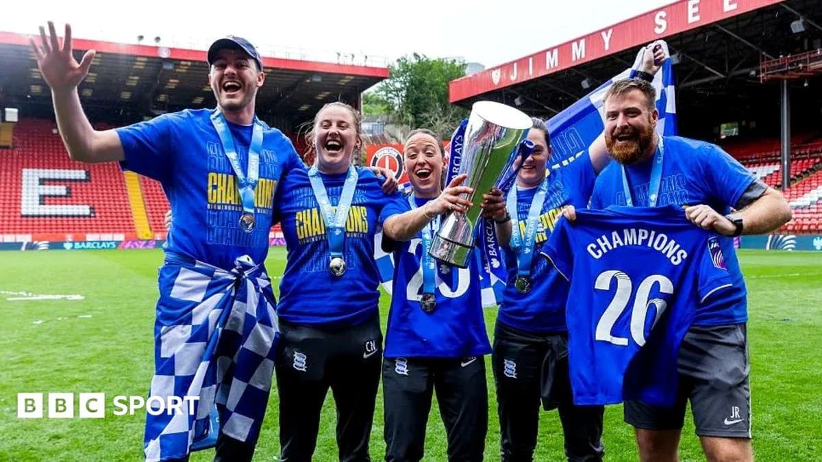 Celebrating team members holding trophy on field