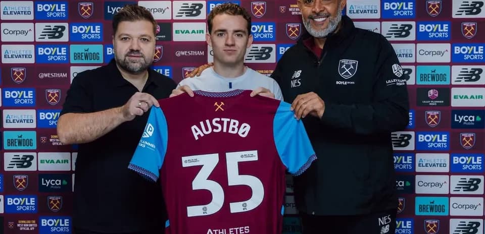 Player holding new jersey with club representatives