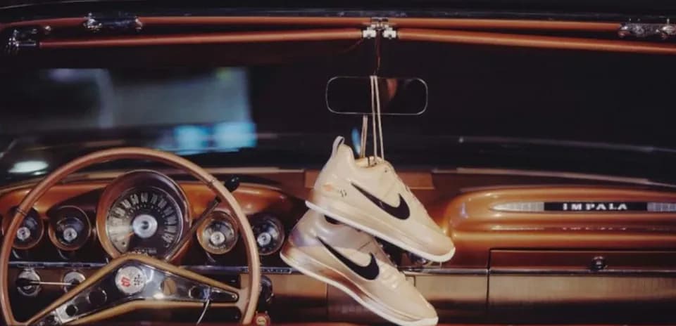 Nike sneakers hanging from vintage car dashboard